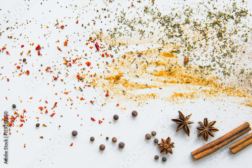 Close-up view of dried aromatic spices and herbs scattered on grey