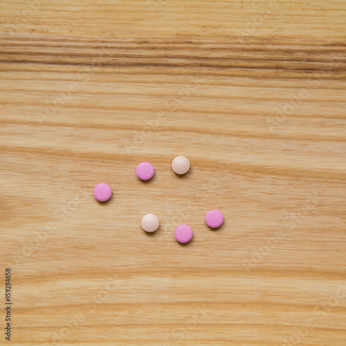 Lot of colorful pills on a wooden table