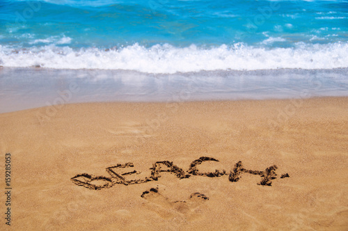 Inscription beach on the sand. Beach season. Rest on the sea