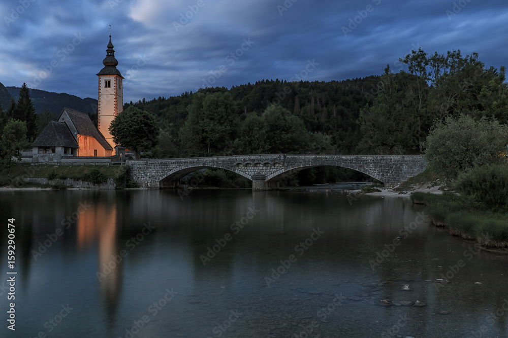 Bohinj, Slovenia - June 5, 2017: Church of St John the Baptist in Lake Bohinj, a famous destination not far from lake Bled in Slovenia, at sunset.