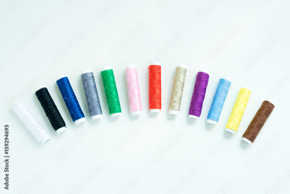 Spools of colours threads or call yarns on rolls for sewing isolated on white background Spools of colours threads or call yarns on rolls for sewing isolated on white background