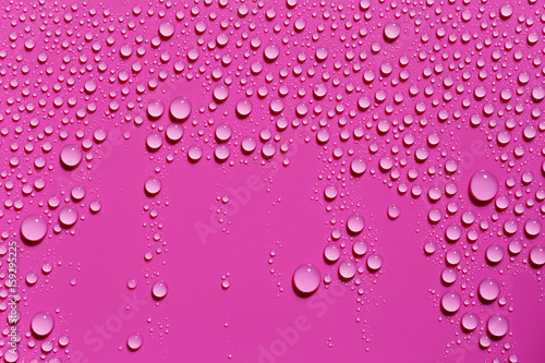 Drops of water on a fuchsia color surface, abstract background