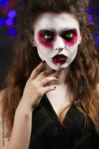 Obraz na plátně Young woman in color contact lenses, with Halloween makeup at party, closeup
