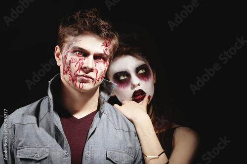 Foto Young people in color contact lenses, with Halloween makeup on black background
