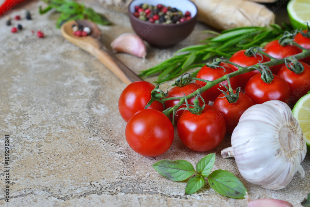 Food background with different ingredients on a marble background. Cherry tomatoes, rosemary, garlic, pepper, lime. Top view. Food background with different ingredients on a marble background. Cherry tomatoes, rosemary, garlic, pepper, lime. Top view.