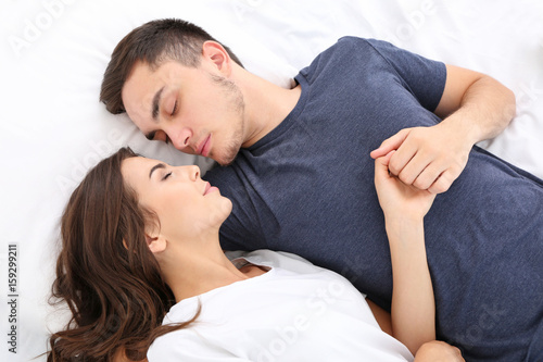 Beautiful young couple lying in bed