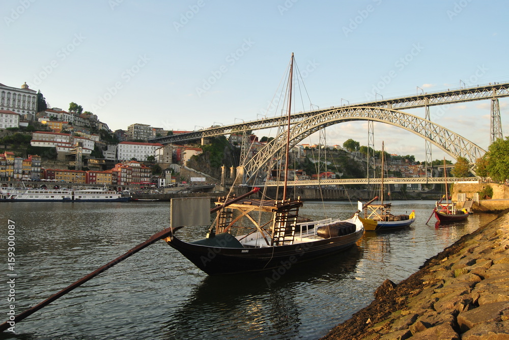 Dois Barcos Rabelos parados no cais de Vila Nova de Gaia ao final da tarde com ponte Dom Luís por trás