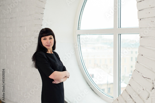 Wallpaper Mural A girl in a black dress is standing in front of a big window in the office Torontodigital.ca