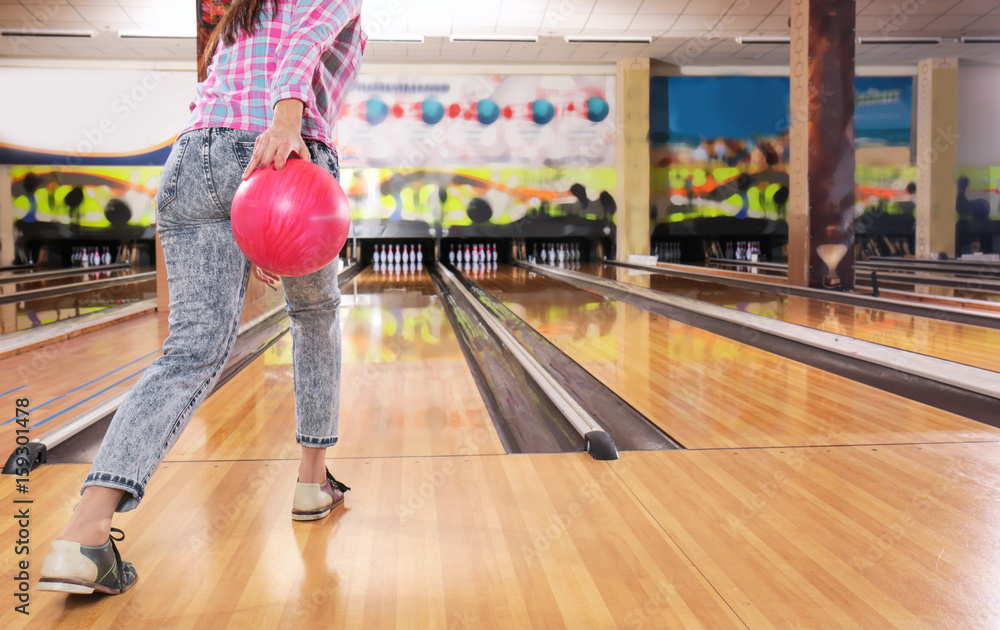 Obraz premium Young woman with ball in bowling club
