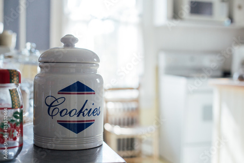 Fotografering Huge white cookie jar on the kitchen shelf of typical american house, with pastr