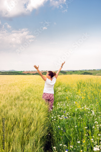Adult woman enjoys the diversity of wheat and rape cultures