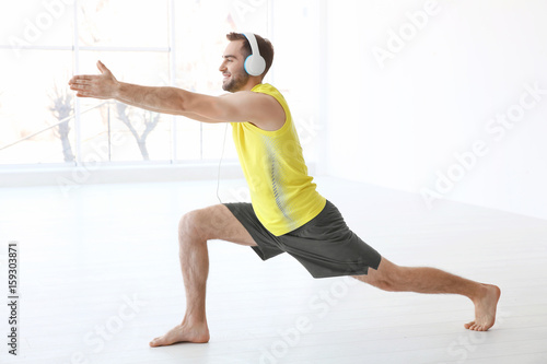 Man doing yoga and listenin...
