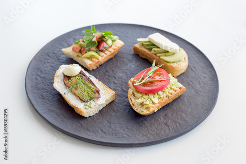 Variety of toast with vegetables as avocado, tomato, eggplant, cucumber, garlic and cheese