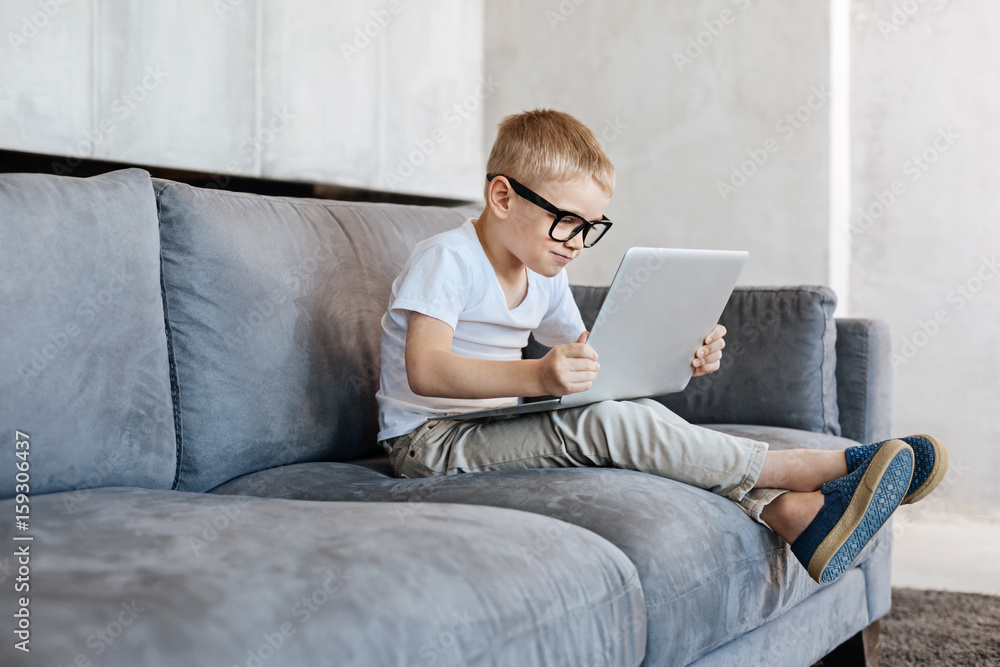 Attentive savvy kid reading something in the internet Attentive savvy kid reading something in the internet