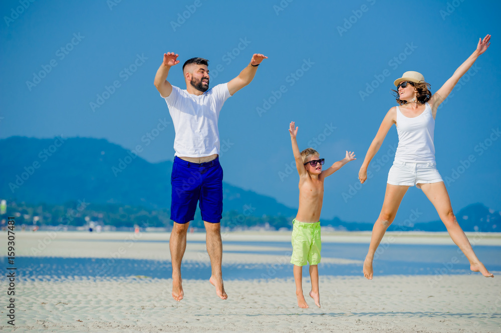 Happy young family of three having fun on the desert sunny beach Happy young family of three having fun on the desert sunny beach