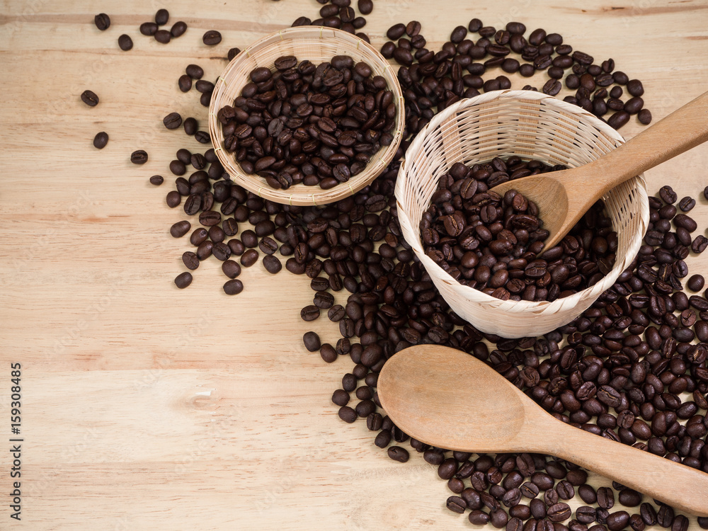 coffee beans in basket weave and wood spoon on wood table coffee beans in basket weave and wood spoon on wood table