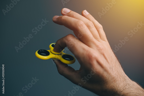 Wallpaper Mural Yellow fidget spinner in male hand Torontodigital.ca