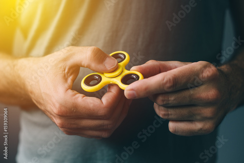 Foto Yellow fidget spinner in male hand