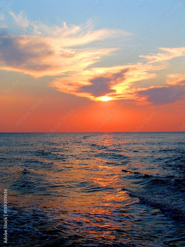 Obraz premium Beautiful sunset on sea with solar path in blue orange colors
