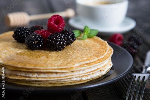 Thin pancakes with fresh berries and coffee