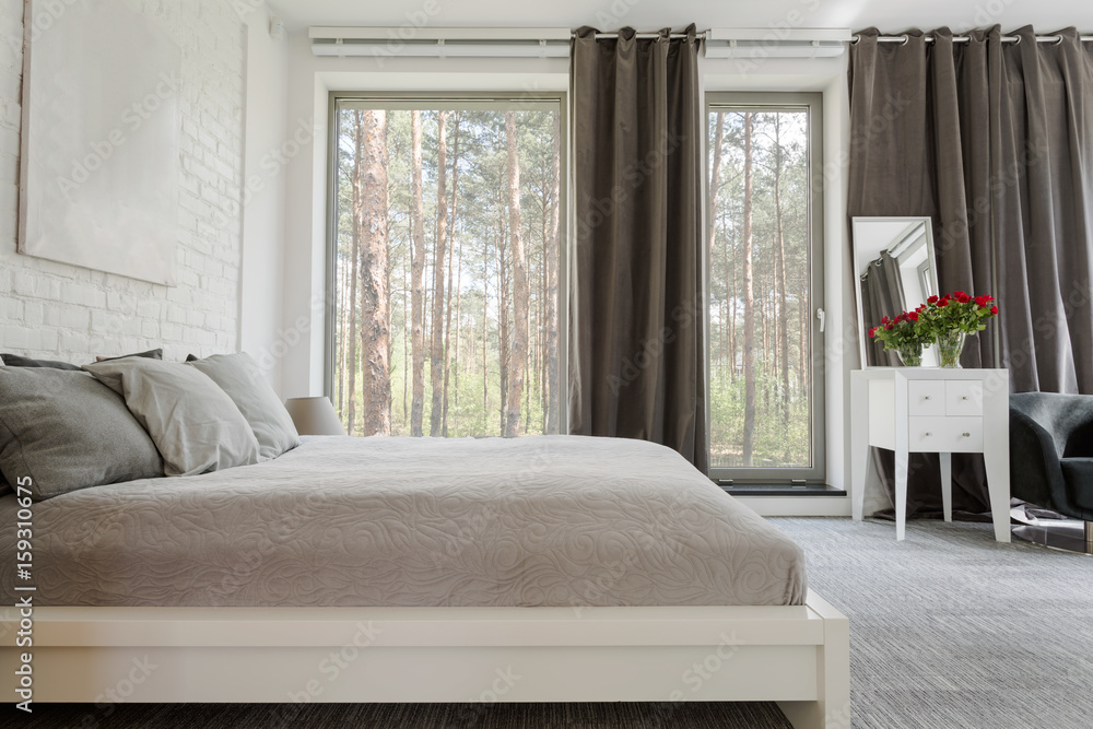 Comfortable king-size bed in a spacious bedroom Comfortable king-size bed in a spacious bedroom