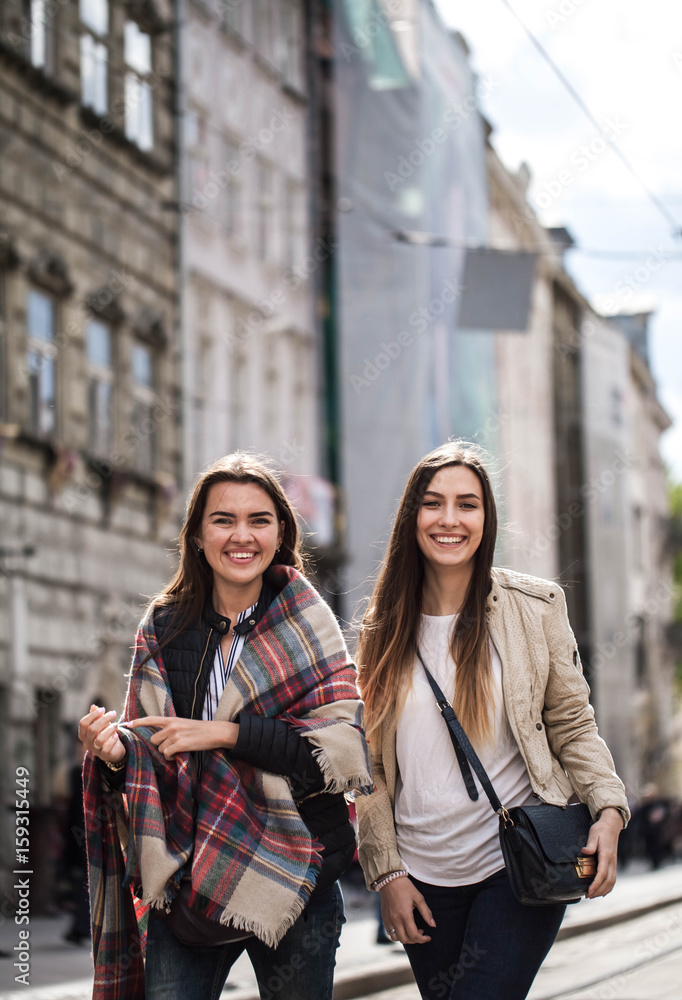 Two girls are walking around the old town and talking