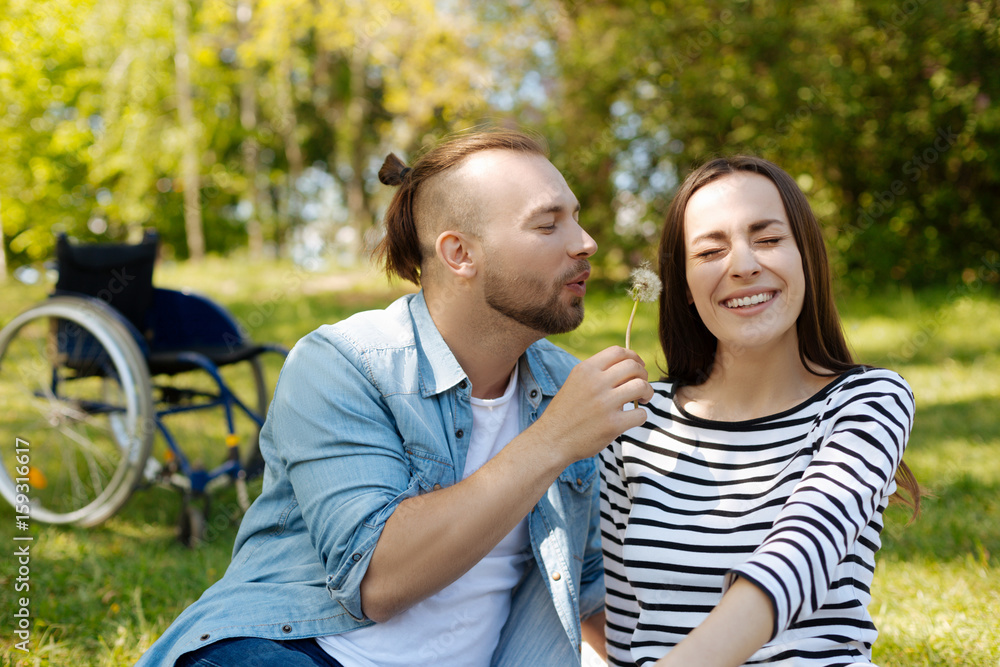 Fototapeta premium Romantic male person blowing on dandelion