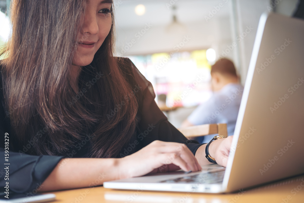 Closeup image of an Asian business woman working and typing on laptop keyboard in office Closeup image of an Asian business woman working and typing on laptop keyboard in office