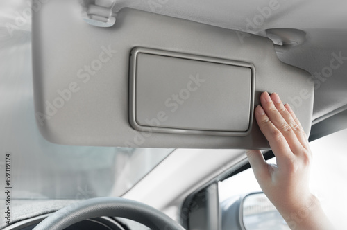 woman hand holding sun visor interior inside car photo