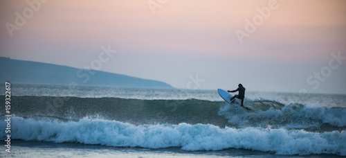 Surfer catching a wave at sunset