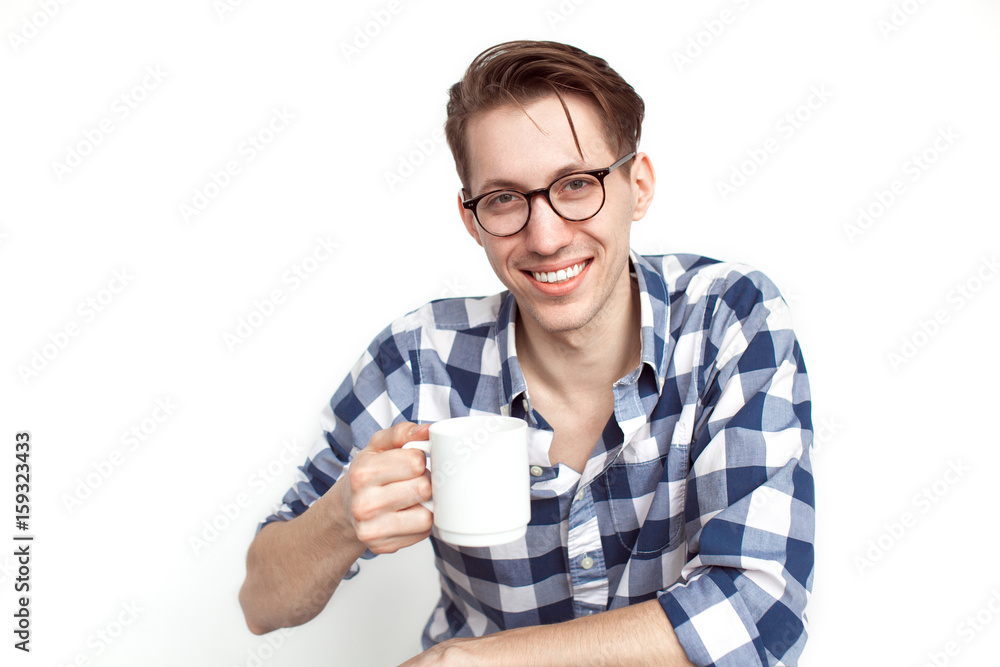 Smiling young man holding white mug Smiling young man holding white mug