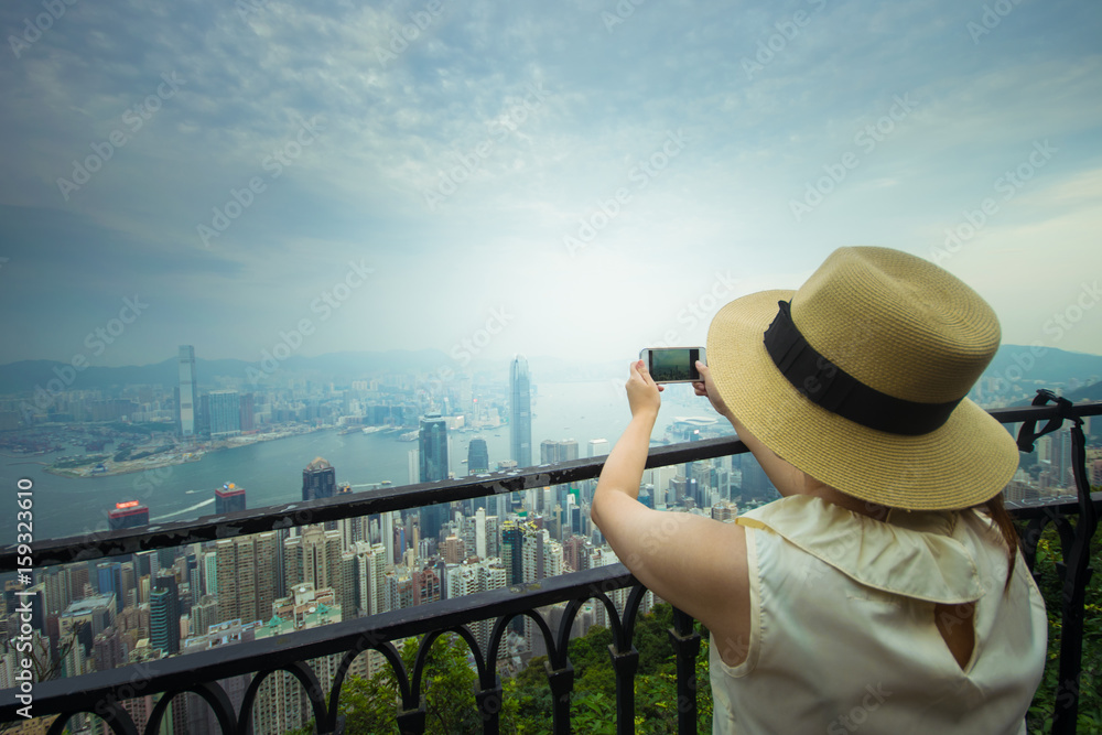 Woman tourist is taking photograph of view beautiful in Hong Kong business landmark district. 
