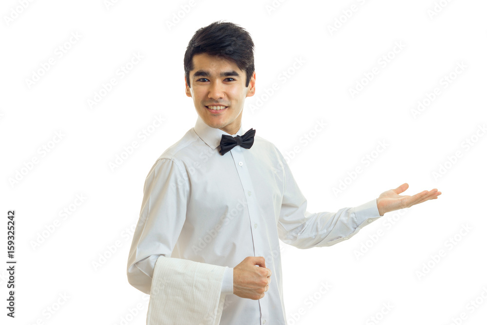 beautiful charming waiter in a white shirt smiles and holds out his hand toward the beautiful charming waiter in a white shirt smiles and holds out his hand toward the