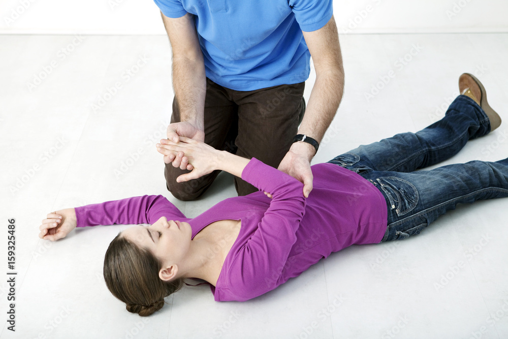 Fototapeta premium First aid techniques : placing the victim in the recovery position Step 2 : Take the victim's other arm, put the back of their hand against their ear Keep the victim's hand pressed against their ear