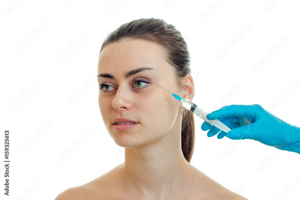 the face of a young pretty girl without makeup which doctor does prick isolated on a white background the face of a young pretty girl without makeup which doctor does prick isolated on a white background