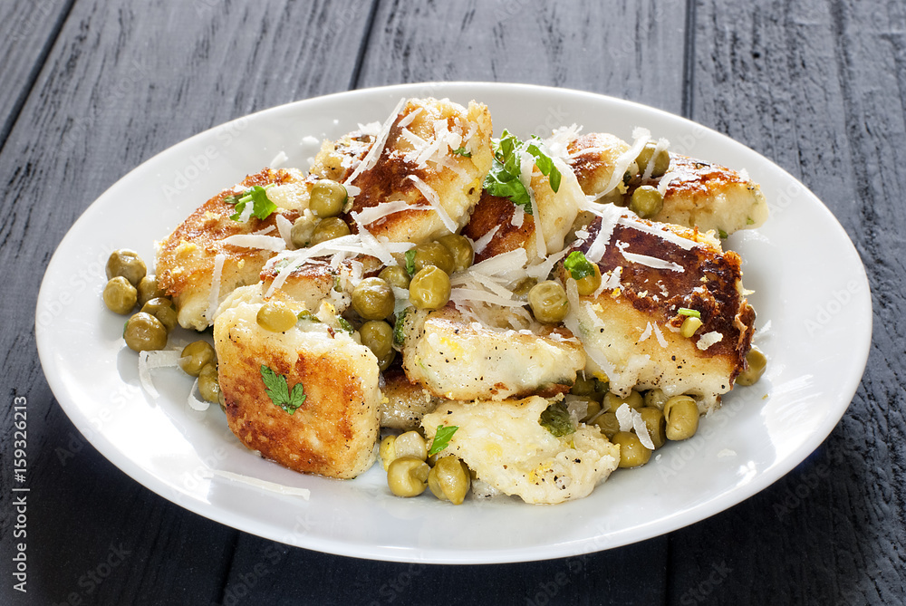 Potato gnocchi in a plate on a black table