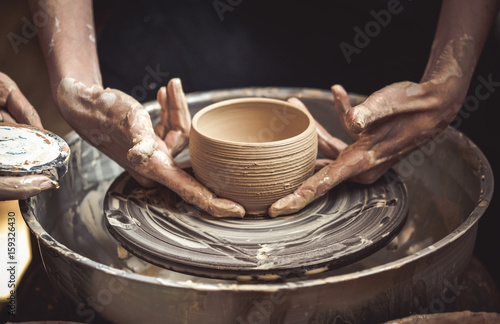 A raw clay pot in the hands of a potter photo