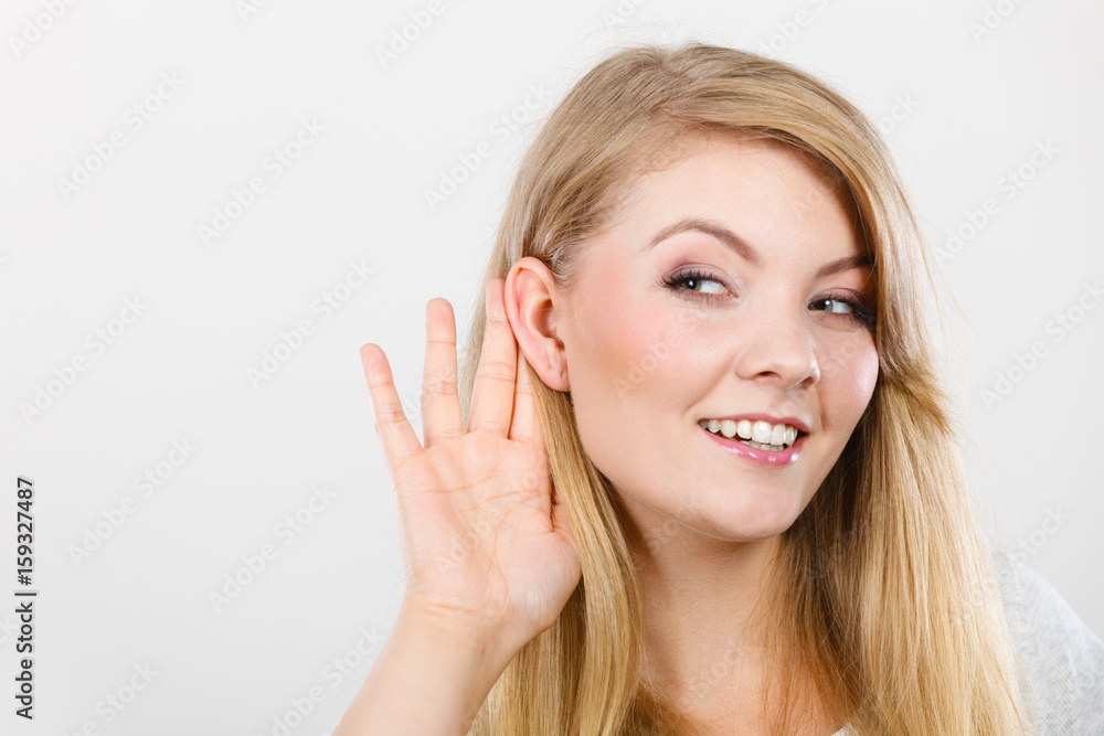 Woman putting hand ear to hear better Woman putting hand ear to hear better