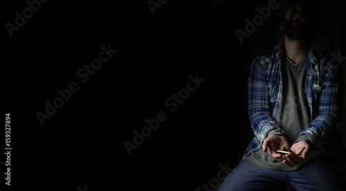 black background with bullet in hands man