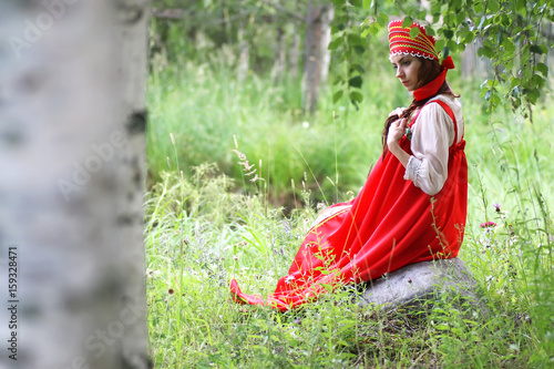 Slav in traditional dress is sitting in nature