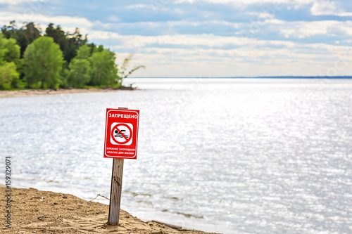 Fototapeta Naklejka Na Ścianę i Meble -  Warning sign on the river - bathing is forbidden, dangerous to life