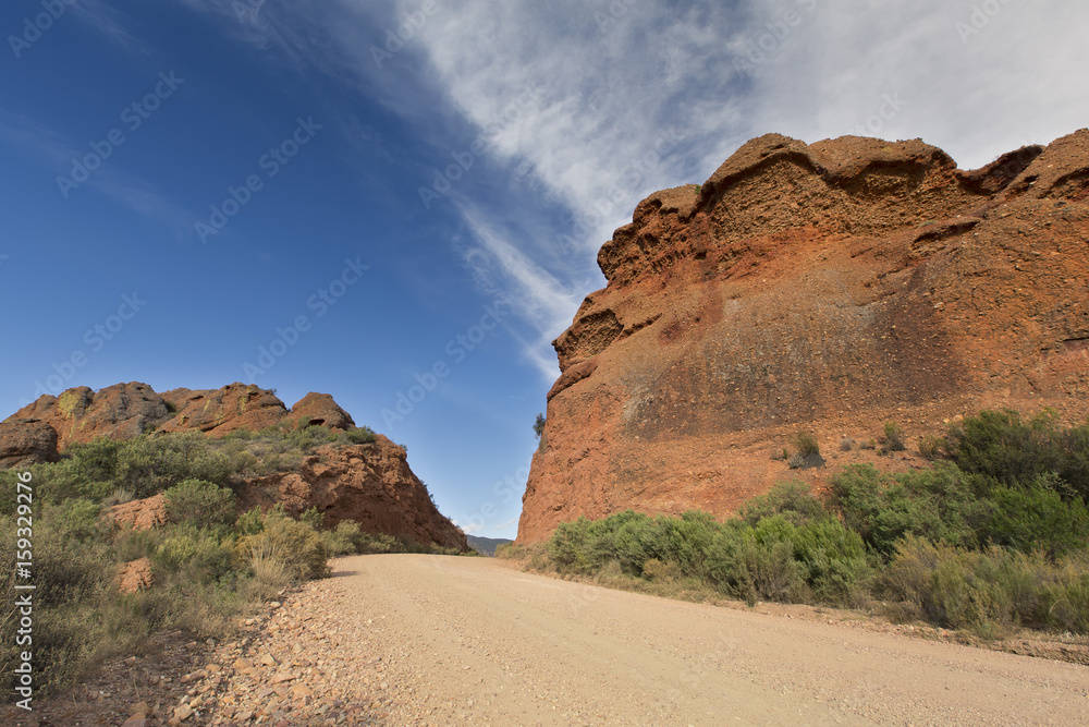 Dirt road leading over a high mountain pass in daytime Dirt road leading over a high mountain pass in daytime