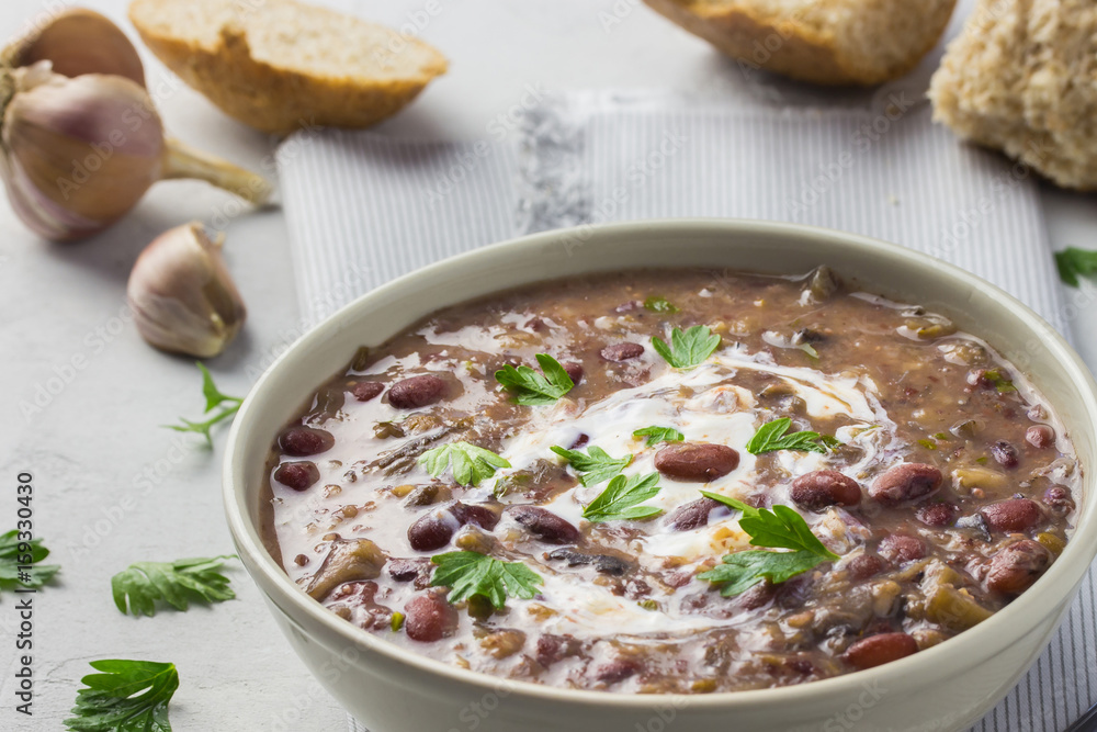 Healthy bean soup in a bowl on concrete background with whole grain bread. Healthy bean soup in a bowl on concrete background with whole grain bread.