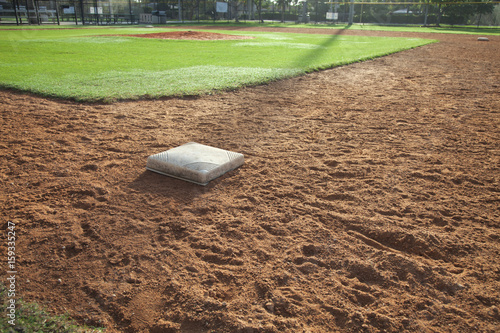 Baseball field infield with first base in the foreground photo