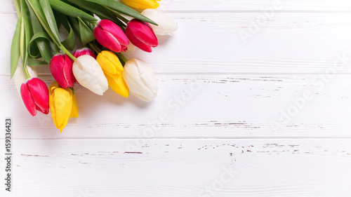 Yellow, pink  and white tulips flowers  on  vintage wooden background.