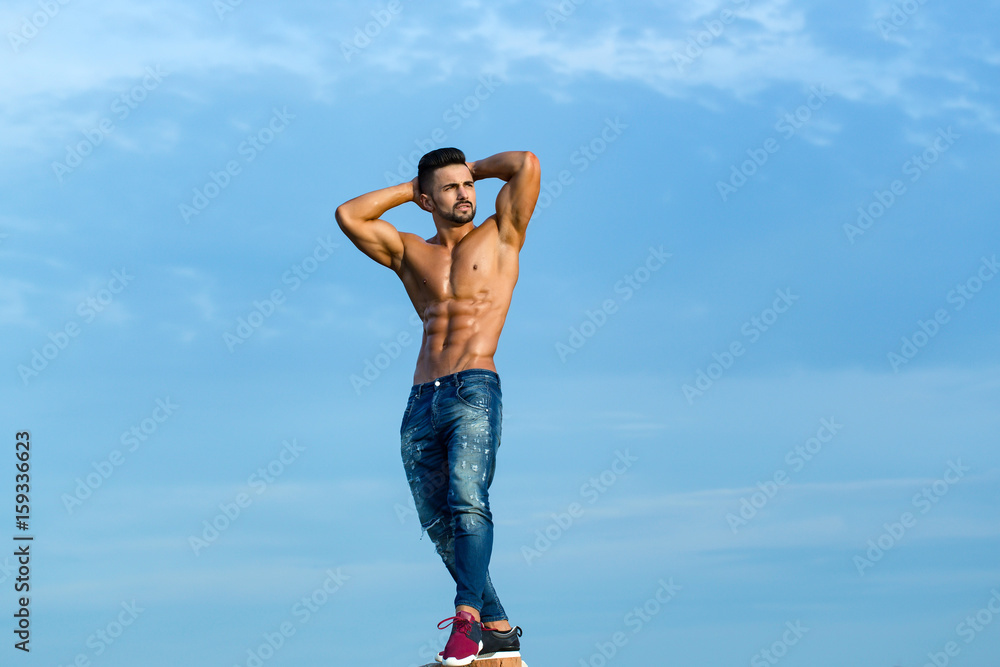 macho guy with muscular body in sunglasses on blue sky macho guy with muscular body in sunglasses on blue sky
