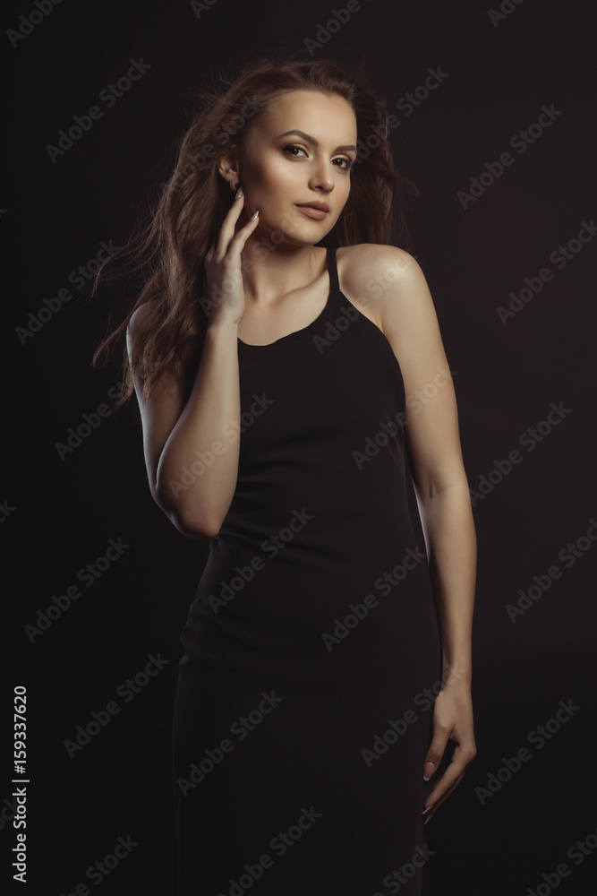 Pretty brunette model in black dress posing at studio Pretty brunette model in black dress posing at studio