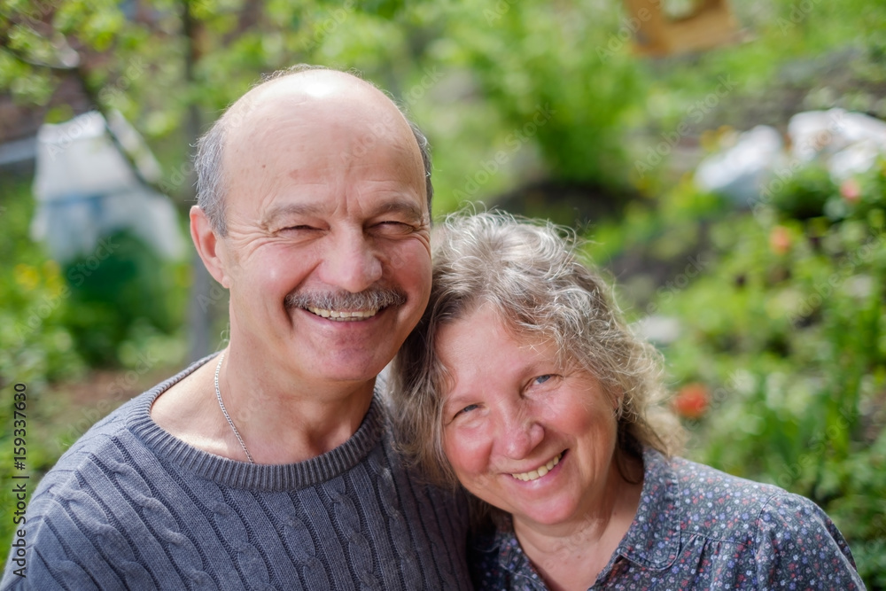 Loving Mature Couple In Back Yard Garden in Sunny Day Loving Mature Couple In Back Yard Garden in Sunny Day
