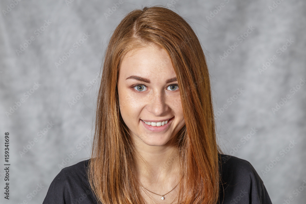 Fototapeta premium Girl at the age of nineteen poses on a light background for advertising