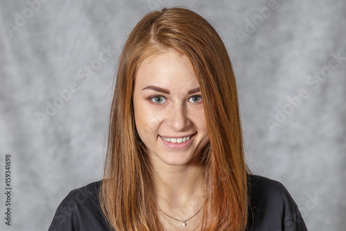 Girl at the age of nineteen poses on a light background for advertising